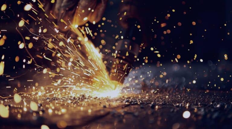 bright sparks caused by a laser welding beam against a dark background