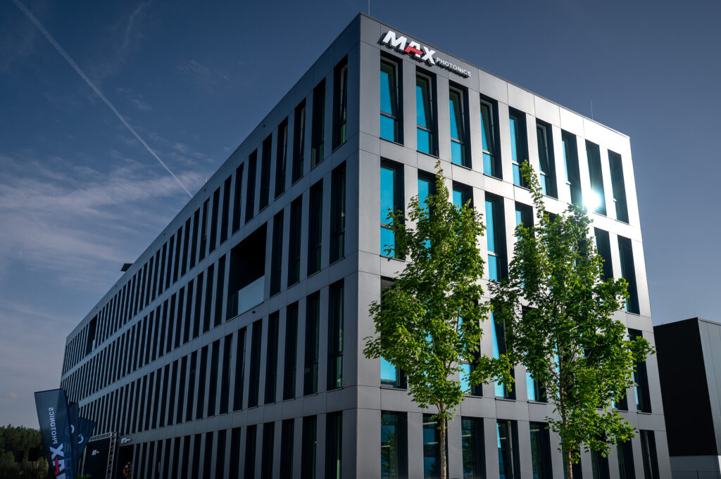 Modern grey building with windows and 2 tree in front of it